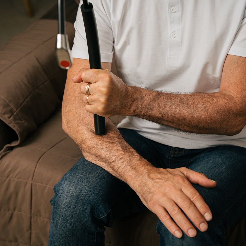 A person using Theratsu's accupressure point to massage their forearm.